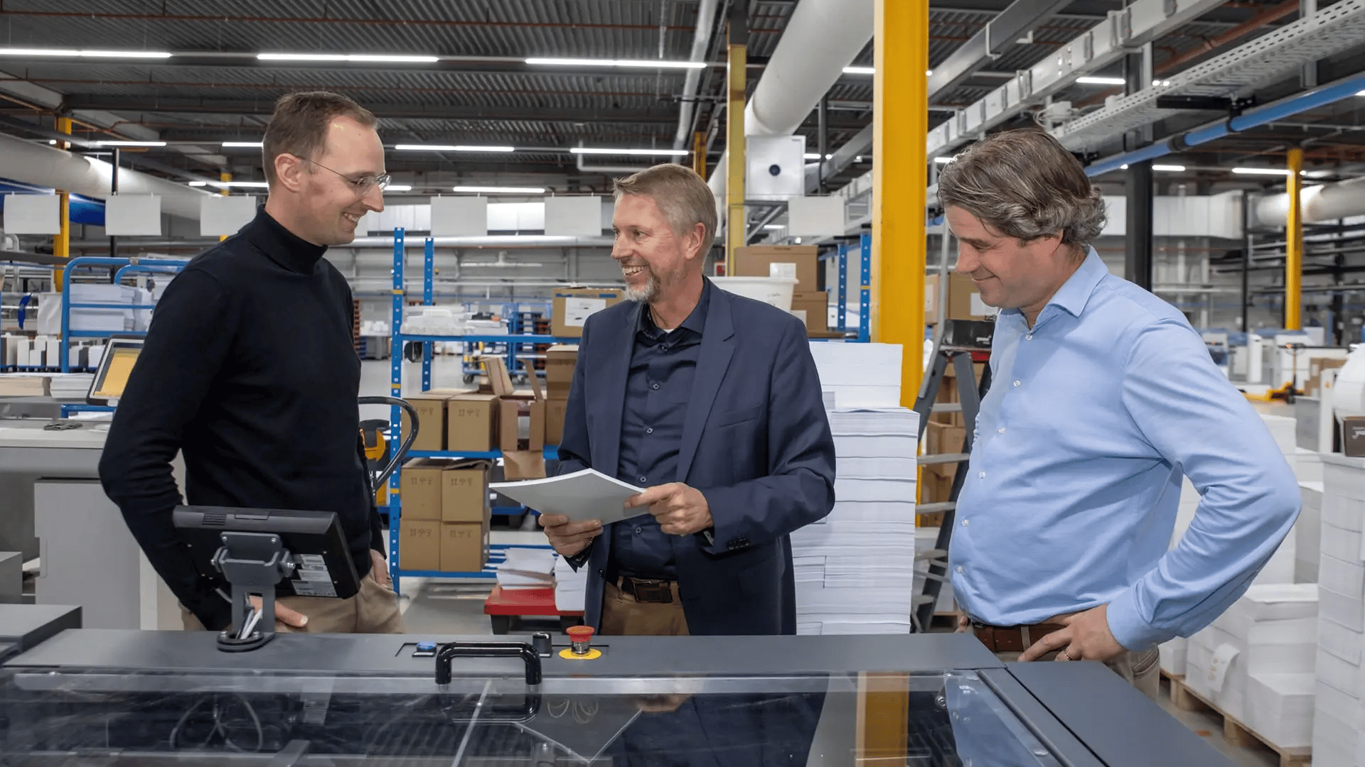 Three men giving a sheet perforator demo